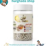 Pristine White Pepper whole peppercorns in a clear jar with wooden bowl and scoop